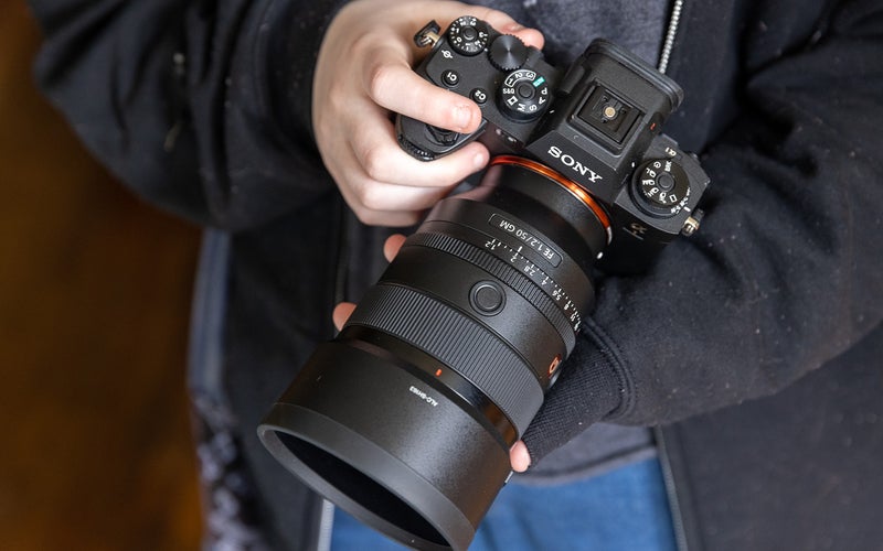 A hand holds the Sony A1 mirrorless camera