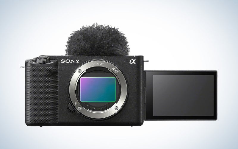 The black Sony ZV-E1 interchangeable lens vlogging camera with screen flipped out against a white background