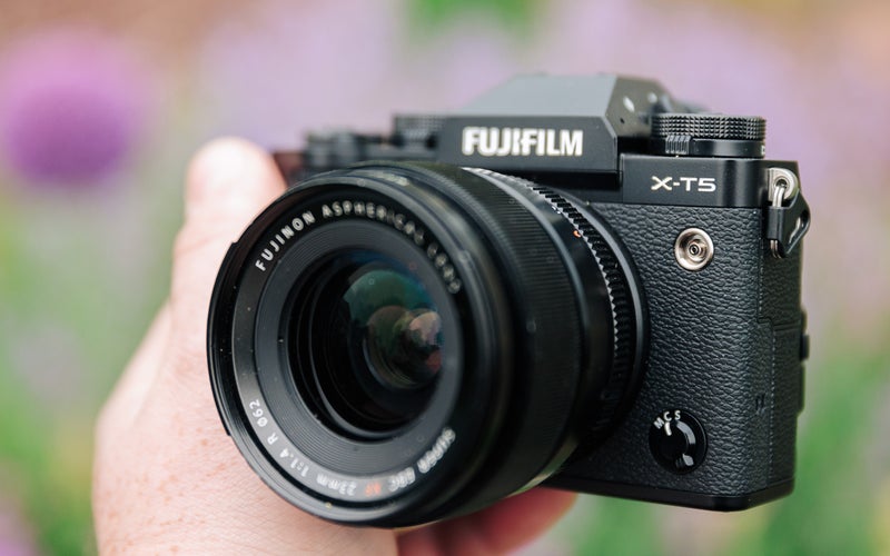 Fujifilm X-T5 in front of blurry flowers at an angle