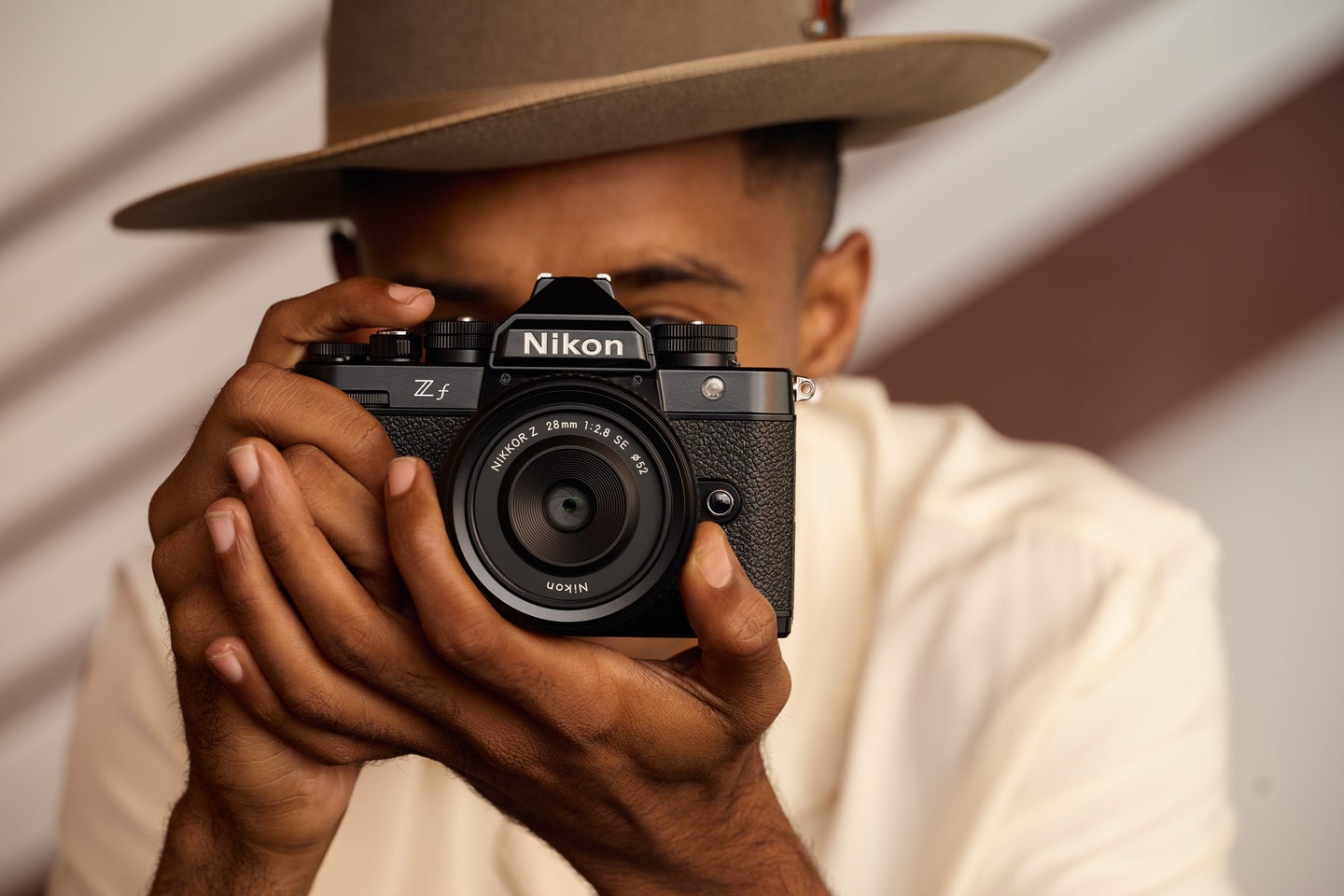 The retro-looking Nikon Z f held up to a person's eye